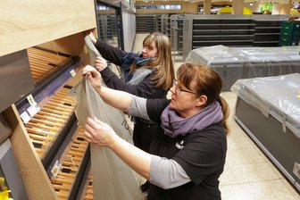 Alles muss raus nach dem Großbrand bei Edeka in Lichtenstein - Vor den anstehenden Bauarbeiten im Edeka Nüßler Lichtenstein decken Verkäuferin Kerstin Hemmann (vorn) und Auszubildende Sophie Wegner die fest eingebauten Regale ab.