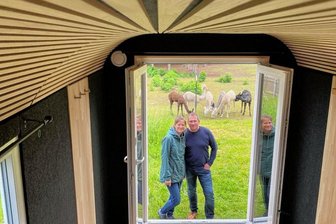 Alpakahome: Die Erlebnisnächte gehen weiter - jetzt im Bauwagen - Blick aus dem stylish gestalteten Bauwagen: Mirjam und Tobias Klose von Alpakahome Brunn haben aus einem baufälligen Bauwagen ein Schmuckstück gezimmert - mit PV-Stromversorgung, moderner Dämmung, Akustikwänden und Doppelbett. Im nächsten Jahr sollen die Gäste durch die Doppelflügeltür auf eine Terrasse mit Vordach treten können - zum Frühstücken mit den Alpakas zum Beispiel. Das Foto zeigt den Wagen auf dem Alpakahof, ab Anfang Juni steht er auf einer Alpaka-Weide weiter unten im Dorf.