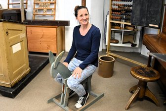 Als unartige Kinder im Vogtland auf die Eselsbank mussten: Schulleiterin stellt zum Neumarker Ortsjubiläum Kurioses zusammen - Simone Dürbeck auf der Eselsbank des temporären Schulmuseums. Ganz so lustig war die Schulstrafe damals nicht.