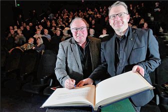 "Also wurde und ist Kino mein Leben": "Kinopolis"-Betriebsleiter Thomas Erler verabschiedet sich in Freiberg - Mit einem Eintrag in das Silberne Buch der Stadt Freiberg überraschte Freibergs OBM Sven Krüger (rechts) Thomas Erler bei seiner Verabschiedung.
