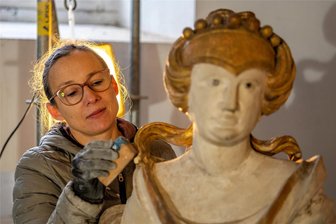Altar im Gerüst: Restauratoren bringen Wechselburger Kirche neuen Glanz - Restauratorin Gisa Hofmann reinigt eine Figur am Altar an der Wechselburger St.-Otto-Kirche. Unter anderem an dieser Figur fehlte ein Finger und eine Taube ist noch in der Werkstatt.