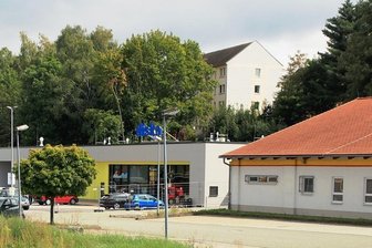 Alte Diska in Lengenfeld: Schnäppchen folgen auf Lebensmittel - Links die neue Diska, rechts die alte Diska, die jetzt umgenutzt werden soll. Davor die wilde Fläche, auf der die großen Laubbäume standen, für die noch kein Ersatz geschaffen ist. 