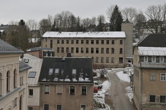 Alte Fabrik im Erzgebirge soll verschwinden - Geschichte beginnt bei bekanntem Textilfabrikanten - Die ehemalige Hausschuhfabrik in Schönheide (Gebäude hinten mit dem Fahrstuhlturm) soll abgerissen werden.