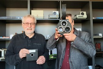 Alte Rechentechnik macht im Vogtland Schule - Werner Seeling (links) fühlt sich mit einer Acht-Zoll-Diskette an alte Lehrerzeiten erinnert, Andreas Wisser muss beim Händeln der Profi-Filmkamera AK 16 etwas Kraft aufbringen.