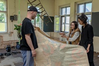 Alte Stickerei in Grünbach wird zu Pfingsten zur Galerie auf Zeit - Petra Gronem-Schlosser (Mitte) mit Franziska Junge (r.) und Rafael Klitzing in der Alten Stickerei Grünbach. Die historischen Stickbahnen werden als Leinwand für die Junges Videoinstallation dienen.