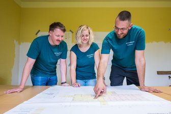 Alte Textilfabrik in Lugau soll wieder genutzt werden: Neuer Verein setzt auf Inklusionsangebote - Sören Funke (v.l.), Esther Grübler und Eric Harzer über Bauplänen für das „Haus Feldblick“.