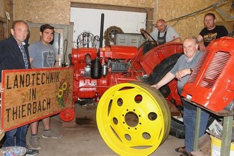 Alter Schlepper wird für Oldtimertreffen in Thierbach fit gemacht - Sie begeistern sich für alte Landtechnik: Bernd Michel (von links) und Alexander Riedel sowie André Riedel, Besitzer des roten Schleppers der Marke Famulus 36. Vorbesitzer war Joachim Busch. Chris Simon (rechts) organisiert mit seinen Oldtimerfreunden seit 2019 die Thierbacher Treffen.