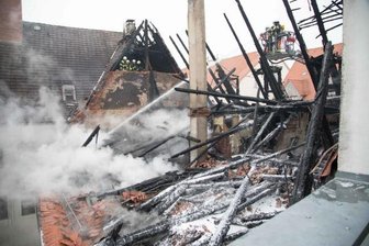 Altstadt-Brand: Gedenkfeier für die Opfer - Das Haus mit ausgebranntem Dachstuhl an der Akademiestraße 5: Ein Totalschaden in sechsstelliger Höhe, wie es von Seiten der Stadtverwaltung hieß. Die Dachdecker haben bereits am Montag die benachbarten Dächer, die durch die Flammen in Mitleidenschaft gezogen wurden, notdürftig repariert.