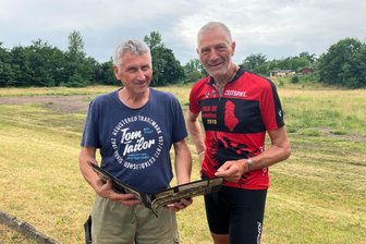 Am „Roten Hügel“: Warum ein bekannter Fußball-Historiker in Meerane Station machte - Buchautor Hardy Grüne (rechts) lässt sich vom Meeraner Jörg Rudel (links) auf alten Fotos zeigen, wie es früher auf dem „Roten Hügel“ aussah.