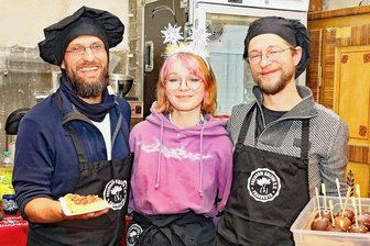 Andrang auf Indoor-Weihnachtsmarkt in Werdau - Rico Runer, Ronja Drese und Frank Drese (von links) vom Fraureuther Verein "Freiraum Kultur" verwöhnten die Besucher mit Schokoäpfeln und Waffeln.