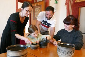 Annas Kräutersalz: Wie die Augustusburger Kurfürstin Einfluss auf die Herrschaft nahm - Doreen Zeisig alias Kurfürstin Anna hilft Hanna, Philipp und Kristin Fischer (von links) bei der Herstellung des Kräutersalzes.