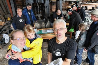 Ansturm auf die offenen Denkmale in Mittelsachsen - Tim Meyer zeigt in der Schmiede Friedrich August in Großschirma die beiden Seiten der neuen Medaille mit dem Motiv des Freiberger Tivolis. Lysann Christoph und Jasmin (7) aus Halsbrücke waren unter den Gästen. 