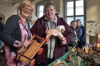 Ansturm auf ersten Schneeberger Weihnachtsflohmarkt - Annett Eckert (r.) ist am Stand von Antje Schäfer (l.) fündig geworden und hat ein Spielzeug-Pferdefuhrwerk mit nach Hause genommen.