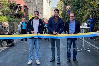 Anwohner setzen in Markneukirchen Wunsch nach Einbahnstraße durch - Zur Feier des Tages gönnte sich die Stadt Markneukirchen extra ein neues Straßeneinweihungs-Band in Stadtfarben. Fabio Kurzendörfer von der Baufirma UTR, Bürgermeister Toni Meinel (parteilos) und Planer Matthias Kreul (von links) griffen am Dienstagnachmittag zur Schere.