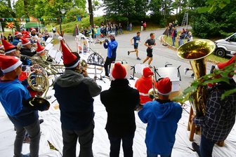 Aperol Spritz im Kopf und Schaum im Haar: Wie eine junge Frau den Gassenlauf erlebt - Auf der winterlichen Fanmeile an der Kirche heizt der örtliche Posaunenchor den Teilnehmern ein.
