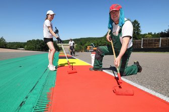 Arbeiten bei 61 Grad Celsius überm Asphalt: Heißer Job am Sachsenring - Mia Rahnfeld und Bert Silbermann gehören zu 14 Helfern, die in diesem Jahr die Fahrbahnmarkierung am Sachsenring bei Gluthitze erneuern.