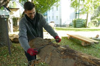 Arbeitslose halten Zschopauer Wanderwege in Schuss - Marcus Gillner entrindet eine Baumstammhälfte. Daraus fertigen AGH-Teilnehmer Bänke, die an Wanderwegen um Zschopau aufgestellt werden.