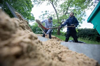 Arbeitspflicht für Asylbewerber: Wie ist der Stand im Vogtlandkreis? - Alivio Rezario aus Venezuela (links) und Yurlan Rivero aus Tunesien sieben in Plauen frischen Sand für den Sandkasten.