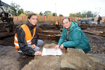 Archäologen finden knapp unter der Erdoberfläche Hinweise auf die Bebauung der Zwickauer Vorstadt im 19. Jahrhundert - Grabungsleiterin Nicole Eichmann (links) und Rebecca Wegener, Referentin im Landesamt für Archäologie, vergleichen einen alten Plan mit den Funden der Grabungsstelle.