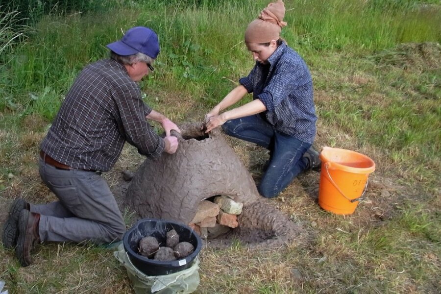 Archäologin will bei Experiment in Mylau Eisen wie vor 2000 Jahren erzeugen - Nadine Holesch mit Thomas Petzoldt beim Nachbau eines Rennofens zur Verhüttung von Raseneisenerz. 