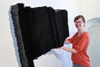 Art-figura-Ausstellung in Schloss Schwarzenberg: Kunstwerke zum Nachdenken und Streiten - Der „Fahne“, hier präsentiert von Schwarzenbergs Museumsleiterin Nadine Bandemer, erkannte die Jury den 1. Preis der Art figura 2023 zu. Das Kunstwerk von Gudrun Fischer-Bomert aus Berlin besteht aus Stahlgewebe und Trinkhalmen und bewegt sich – wie viele Arbeiten dieser Künstlerin – im Spannungsfeld zwischen Politik und Poesie.