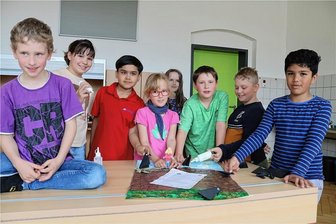 Auer Weltentdecker-Kinder dichten ein Grimmsches Märchen über gute und böse Mächte nach - Tom, Emma, Orfan, Therese, Tamara, Paul, Mika und Maher (von links) vom Hort "Weltentdecker" haben ein Gedicht und Plakat zum Märchen "Die sieben Raben" gestaltet.