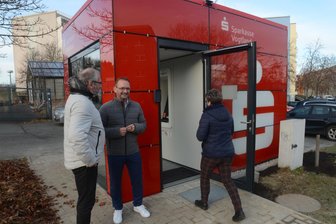 Auerbacher haben ihren Sparkassenwürfel wieder - Während die ersten Kunden den Würfel betreten, freuen sich OB Jens Scharff (l.) und Robert Hutschenreuther von der Sparkasse über die Wiedereröffnung.