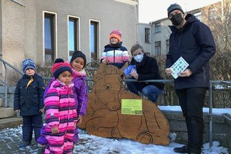 Auerbacher Krippenweg-Figuren finden im Westerwald Anklang - Mit dem Ochsen, der am Freitag von Kindern der Schwalbengruppe des Evangelischen Kindergartens in Empfang genommen wurde, umfasst der Auerbacher Krippenweg jetzt zehn Figuren. Geschaffen hat alle GemeindepädagogeDaniel Arnstadt (r.); die Figuren der Krippe in der St. Laurentiuskirche dienten als Vorlage. Pfarrerin Mandy Rabe liefert die Texte für die Stationen des Krippenweges, an dem auf die Besucher auch Geschenke warten.