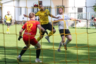 Auerbacher sichern sich den Verbleib in der Fußball-Sachsenklasse trotz knapper Mittel - Gute Defensivarbeit des Auerbachers Marvin Todt (gelbes Trikot), der den Ball zu seinem Keeper Lukas Tilgner köpft. Rechts Rico Thomas (BSC Freiberg).