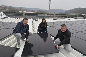 Auf Dach des Erzgebirgsstadions in Aue entsteht weitere gigantische Solaranlage - Montieren symbolisch das letzte Solarmodul auf dem Dach des Auer Stadions: Olaf Albrecht vom FC Erzgebirge Aue (v. l.) sowie Projektleiterin Dajana Franz und Alexander Sesser von Clen Solar.