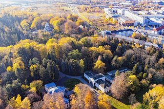 Auf dem Totenacker: Unterwegs auf dem Friedhof von Chemnitz - Links die Feier-, rechts die Leichenhalle, hinten die Kuppel des Krematoriums: So sieht der Städtische Friedhof an Wartburg- (rechts) und Reichenhainer Straße (vorm Krematorium) aus der Luft aus. Waldartige Flächen wechseln sich mit lichteren Abschnitten ab. Laut Friedhofsverwalterin Anett Domin sind in der Kategorie Einzelbäume allein 1250 erfasst. Während die Ursprungsanlage aus dem Jahr 1874 heute den Charakter eines Parks trägt, mutet der Urnenhain jenseits der Reichenhainer wie ein klassischer Friedhof an. 2400 Urnenbeisetzungen und40 Erdbestattungen pro Jahr zählt der kommunale Friedhofsbetrieb heute.
