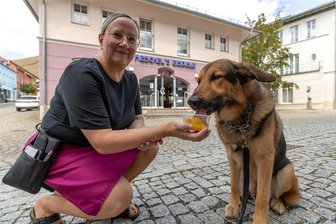 Auf den Hund gekommen: In dieser Treuener Eisdiele gibt es Eis für Vierbeiner - Abkühlung an heißen Tagen. Schäferhundmischling Rocco (5) schleckt das Eis genüsslich aus der Hand von Mandy Pieschel. Seit 2018 führt sie mit ihrem Bruder das Familienunternehmen in Treuen.