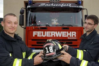 
              <p class="artikelinhalt">Vor der großen Reise nach New York noch ein Fototermin: Oliver Lenk und Sascha Bach gemeinsam mit dessen Vater Uwe Bach (von links) von der Freiwilligen Feuerwehr Sachsenfeld, einem Ortsteil von Schwarzenberg. Der amerikanische Helm ist der ganze Stolz von Oliver Lenk.</p>
            