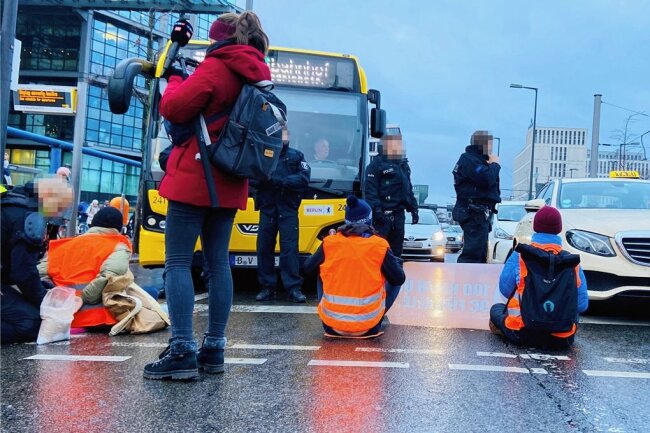 Auf den Spuren der Letzten Generation: Gekommen, um zu kleben - Straßenblockade Anfang Dezember vor dem Berliner Hauptbahnhof. Die Polizeibeamten in der Hauptstadt haben damit längst Routine. Nach 20 Minuten ist die Straße frei. 