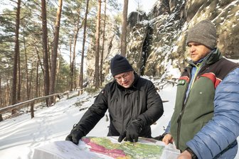 Auf der Spur der heißen Steine: Warum Freiberger Forscher die Felsen der Sächsischen Schweiz untersuchen - Jörn Wichert von der TU Bergakademie Freiberg (links) und Alexander Nestler von der Nationalparkverwaltung Sächsische Schweiz mit einer Karte zur Geologie des Elbsandsteingebirges am Gamrig.