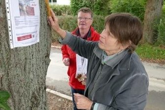 Auf der Suche nach Bella - An einem Baum bringt Kristine Tannenhauer einen von über 100 Steckbriefen an. Unterstützt wird sie bei ihrer Suchaktion von Peter Heimlich und vier weiteren Helfern.
