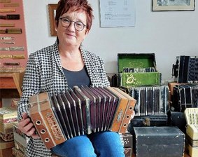 Auf der Suche nach Geschichten zu Konzertina und Bandoneon - Die Chemnitzer Stadtführerin Edeltraud Höfer mit einer Lange-Konzertina im Harmonikamuseum Zwota.