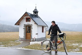 Auf einem klapprigen Fahrrad durchs Erzgebirge: Abenteurer tauscht Foto gegen Übernachtung - Maximilian Gödecke auf der Tour durchs Erzgebirge. Hier an der Kapelle in Kretscham.