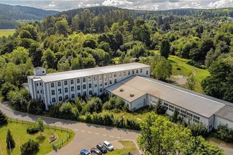 Auf Fabrik-Gelände an Talsperre Falkenstein könnten bald Wohnmobile parken - Drei Gebäudeteile, sechs Garagen und weitere Nebengebäude befinden sich auf dem Areal der so genannten Nabento-Brache unweit der Falkensteiner Talsperre (im Bild links hinten). Zu DDR-Zeiten war es Falgard-Werk 8 der Plauener Gardine. Das zugehörige Grundstück ist etwas größer als ein Fußballfeld. 