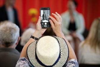 Auf ins Theater, ihr Unentschlossenen: Alles über Dresscode, Applaus und andere Rätsel! - Besucherin mit Handy: Theater ist heute längst kein kultureller Hochsicherheitstrakt mehr!