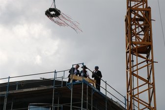 Auf Nachhaltigkeit ausgerichtet: Richtfest für Volksbank-Neubau in Aue gefeiert - Während die Richtkrone einschwebte, schlug Vorstandsmitglied Gerd Koschmieder (links) die letzten Nägel ein, unterstützt von Bauleiter Peter Fritzsche und Zimmerer Benedikt Dües (v. r.).