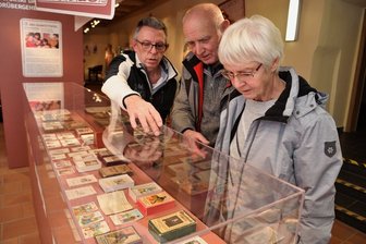 Auf Schloss Voigtsberg in Oelsnitz kann man auf eine Reise in die Welt der Kartenspiele gehen - Andreas Müller (links) aus Rülzheim ist der Hauptleihgeber für die neue Sonderschau "Vier Karten für ein Halleluja" auf Schloss Voigtsberg in Oelsnitz. Er erklärt den Besuchern Birgit (rechts) und Dieter Spranger (Mitte) aus Oelsnitz seine Exponate. 