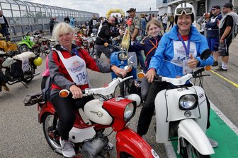 Auf Schwalbe, Star und Sperber über den Sachsenring: Simson-Fans knattern auf „Vogelfrei“-Tour durchs Zwickauer Land - Cindy und Mike Benke aus Mülsen in der Boxengasse auf dem Sachsenring. Mit Nichte Samantha als Mitfahrerin haben sie auf ihren Mopeds Star und Schwalbe am Sonnabend die Wiederauflage der „Vogelfrei“-Rundfahrt absolviert. Knapp 300 Mopeds waren am Start.