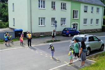 Auf sicheren Wegen durch Klingenthal von der Schule zum Hort - Sicherer Schulweg: Bürgerpolizist Uwe Frank übt mit Klingenthaler Schulanfängern. In der Dürrenbachstraße lernen die Kinder, wie sie die Straßen auch hinter parkenden Fahrzeugen sicher überqueren können.