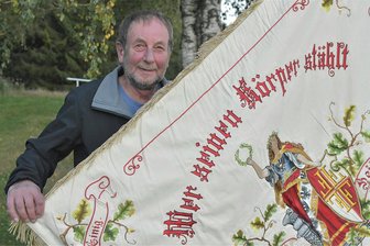 „Auf unseren Wolfgang ist immer Verlass“: Bürgerpreis Muldenhammer für einen Nimmermüden - Seit 1973 ist Wolfgang Riedl - im Foto mit der Traditionsfahne - nicht nur Mitglied der TSG Bau Hammerbrücke, sondern ein allseits geschätzter Aktivposten.