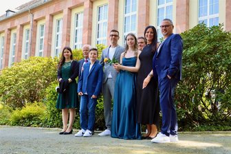 Aufregung, Planungsmarathon und Tränchen: Es ist Jugendweihesaison im Erzgebirge - Patchworkfamilie Kaiser-Gnüchtel, mit Hauptperson Aliya (14) vorne mit Jugendweiherose und Buch vor dem Kulturhaus in Aue.