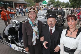 August Horch schaut am Falkensteiner Bahnhof vorbei - August Horch und Fräulein Hermine (alias Bernd Göpfert und Simone Steinbach, rechts) werden am Sonntag im Rahmen der 10. August-Horch-Klassik erstmals dem Falkensteiner Güterschuppen einen Besuch abstatten. Start und Ziel der Oldtimer-Rundfahrt ist wie immer am August-Horch-Museum in Zwickau, im Bild eine frühere Tour, bei der August-Horch-Enkelin Heike Mueller (vorne links) vorbeischaute. 