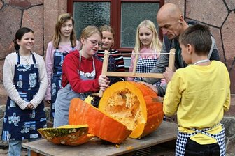 Aus 40-Kilo-Frucht sollen Konfitüre und Eis entstehen - Beim Zerkleinern der Riesenfrucht mit einer Säge bekamen die Schüler Unterstützung von den Hausmeistern.