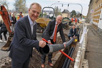 Ausbau des Glasfasernetzes in Glauchau beginnt - Roland Warner, Vorsitzender der Eins-Geschäftsführung, Glauchaus OB Peter Dresler und der Beigeordnete Carsten Michaelis (von links) legen an der Schlachthofstraße symbolisch ein Leerrohr in die Erde.