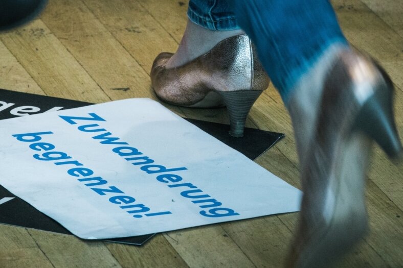 Aussprache am Familientisch - Das Schild mit der Aufschrift "Zuwanderung begrenzen" liegt zwar am Ende des JU-Deutschlandtags achtlos auf dem Boden. Doch dieses Thema bewege die Menschen und habe auch die Beziehung zwischen CDU und CSU erschüttert, räumte Bundeskanzlerin Angela Merkel in Dresden ein.